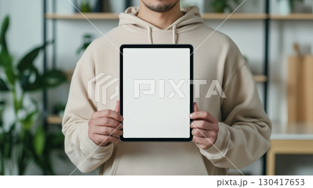 Close up of a man holding a digital tablet with a blank white screen, providing a space for designers to showcase their work in a realistic setting Close up of a man holding a digital tablet with a blank white screen, providing a space for designers to showcase their work in a realistic setting 130417653