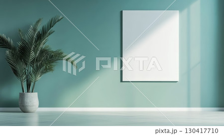 Sunlight illuminates a modern interior featuring a blank canvas on a teal wall, providing a space for design and creativity, complemented by a potted plant 130417710