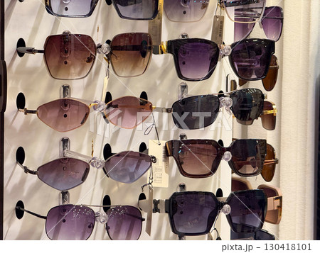 Various sunglasses with colorful lenses and frames displayed for sale in store. Fashion, protection and lifestyle emphasizing accessory, retail, and consumer choice in modern market. 130418101