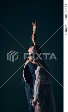 Dancers leaning together with soft closed eyes in intimate stage pose 130418533