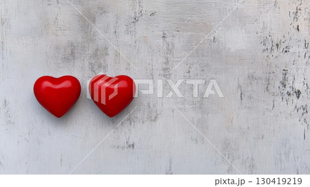 Two red wooden hearts are lying on grey textured background representing love and affection on valentine's day, creating a romantic and minimalist composition with copy space 130419219