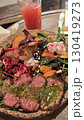Colorful salad bowl with grilled beef slices, vegetables, cheese and herbs next to a glass of juice 130419273