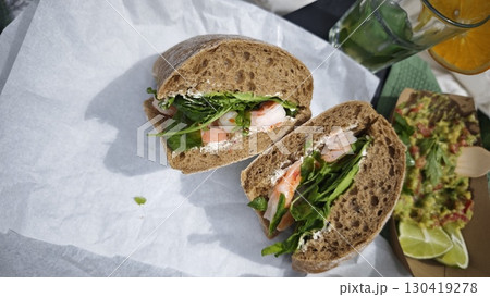 Fresh sandwich with shrimp, cream cheese and greens served with guacamole and lime Fresh sandwich with shrimp, cream cheese and greens served with guacamole and lime 130419278