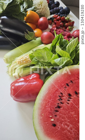 Colorful summer harvest of fresh fruits and vegetables on a white surface 130419280