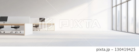 Sunlight flooding an open office space with large windows and empty workstations creates a bright, spacious environment perfect for highlighting company culture 130419425