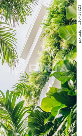 Green plants thriving on the side of a modern white building, enhancing the urban landscape and promoting a sustainable, eco friendly environment through innovative design 130419823