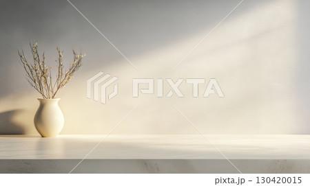 Sunlight illuminates dried flowers in a white vase placed on a white kitchen counter, creating a serene and minimalist atmosphere with ample copy space on the illuminated wall 130420015