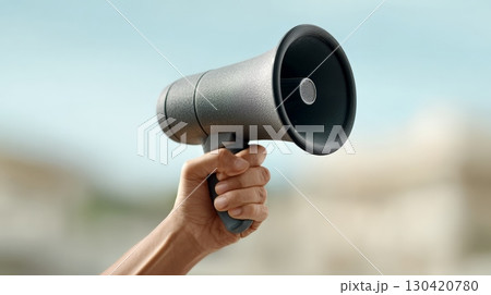 Hand firmly gripping a megaphone during an immigration rights protest rally, conveying a message of dissent and advocating for policy change in the united states Hand firmly gripping a megaphone during an immigration rights protest rally, conveying a message of dissent and advocating for policy change in the united states 130420780
