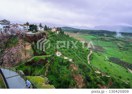 Cliffside View of Ronda Spain with White Buildings and Lush Valley Below. Cliffside View of Ronda Spain with White Buildings and Lush Valley Below. 130420809