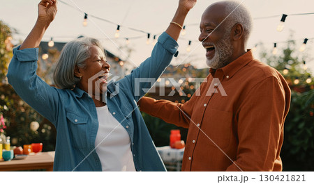 Elderly couple revels in pure joy under twinkling lights, capturing life's happiest moments 130421821