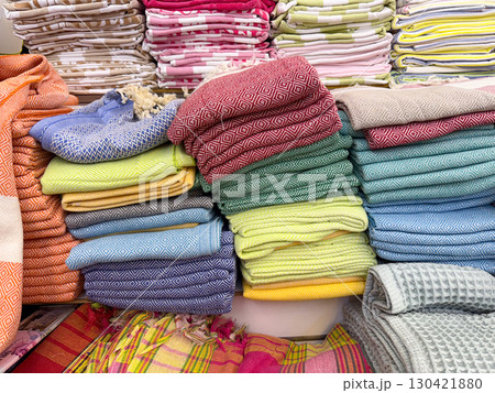 Colorful stacks of towels in various patterns and shades arranged in a shop. Lifestyle, leisure and consumer choice expressed through textile, comfort and everyday household essentials 130421880