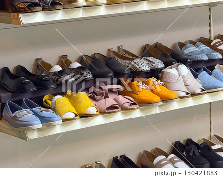 Shelves of shoes in multiple styles, colors and designs displayed in a store. Fashion, consumer choice and retail commerce as a symbol of individuality, lifestyle and modern trends. 130421883
