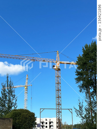 High-rise building under construction with tower crane at a busy construction site, Vertical High-rise building under construction with tower crane at a busy construction site, Vertical 130421896