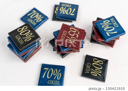 Dark Chocolate Bars Wrapped in Foil with Percentage Indication 65, 70, 80 percent on White Background Dark Chocolate Bars Wrapped in Foil with Percentage Indication 65, 70, 80 percent on White Background 130421910