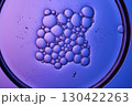 Serum with bubbles in a petri dish on a purple background. 130422263