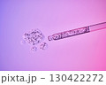 Transparent pipette with a serum texture with bubbles on a purple background. 130422272