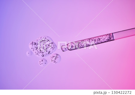 Transparent pipette with a serum texture with bubbles on a purple background. Transparent pipette with a serum texture with bubbles on a purple background. 130422272
