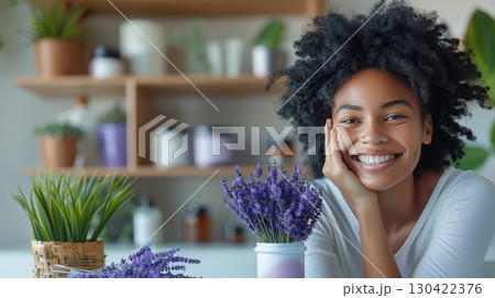 Joyful lady applying lavender cream with lavender bouquet on elegant dressing table 130422376