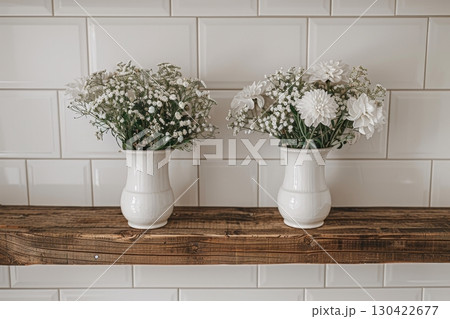 Elegant minimalist wooden shelf featuring white vases and dried floral arrangements for decor 130422677