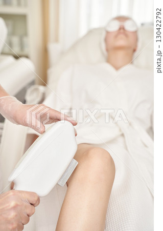 Female adult receiving laser hair removal treatment at spa clinic for smooth 130422792