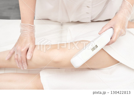 Caucasian female adult receiving laser hair removal treatment on leg in clinic Caucasian female adult receiving laser hair removal treatment on leg in clinic 130422813