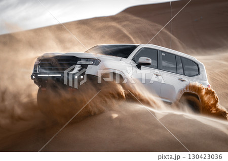 White SUV driving through desert sand, Saudi Arabia 130423036