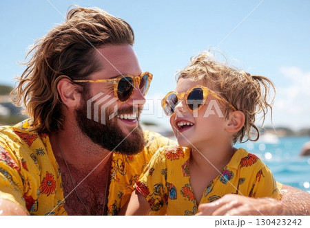Happy father and son enjoy sunny day wearing matching sunglasses and shirts 130423242