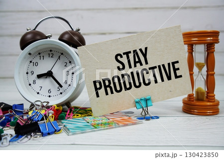 Stay Productive text on paper card with alarm clock and stationary on wooden background 130423850