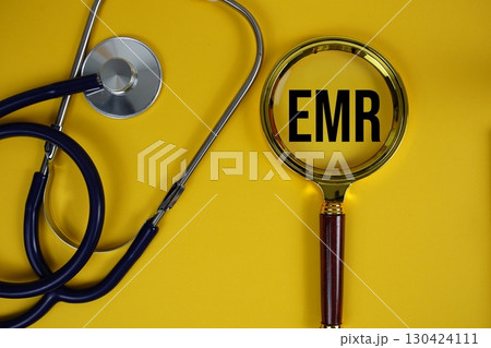 EMR abbreviation of Electronic Medical Records text with Stethoscope and magnifying glass flat lay on yellow background 130424111