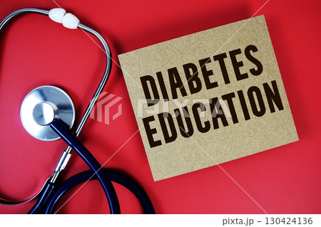 Diabetes Education text written on paper card with stethoscope on red background 130424136