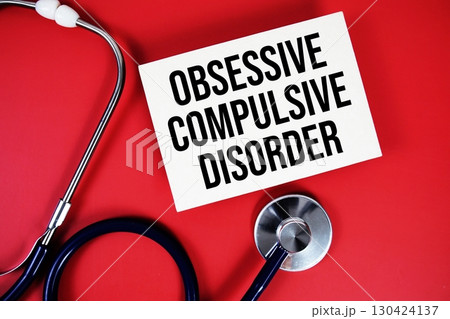 Obsessive Compulsive Disorder text written on paper card with stethoscope on red background 130424137