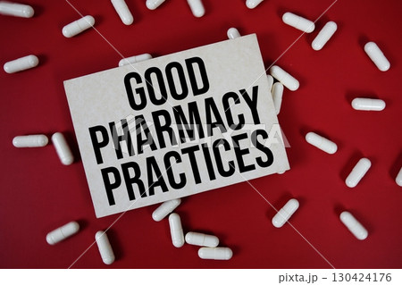 Good Pharmacy Practices text written on paper card with medicine capsule on red background 130424176