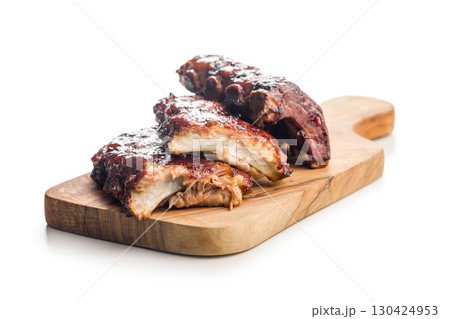 Pork BBQ glazed ribs on cutting board isolated on white background. Pork BBQ glazed ribs on cutting board isolated on white background. 130424953