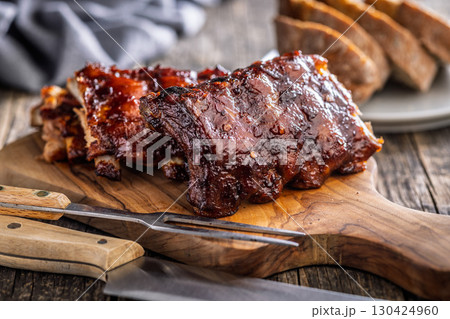 Pork BBQ glazed ribs on wooden cutting board. 130424960