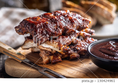 Pork BBQ glazed ribs and sauce on wooden cutting board. Pork BBQ glazed ribs and sauce on wooden cutting board. 130424961