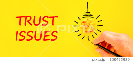Trust issues symbol. Concept word Trust issues on beautiful yellow paper. Businessman's hand. Light bulb icon. Beautiful yellow paper background. Business trust issues concept. Copy space. Trust issues symbol. Concept word Trust issues on beautiful yellow paper. Businessman's hand. Light bulb icon. Beautiful yellow paper background. Business trust issues concept. Copy space. 130425929