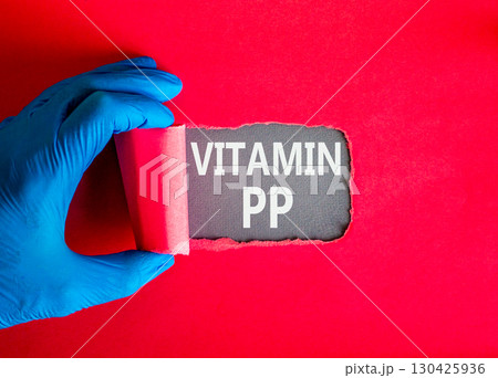 Vitamin PP symbol. Concept words Vitamin PP on beautiful grey paper. Doctor hand in blue medical glove. Beautiful red background. Medical healthy lifestyle Vitamin PP concept. 130425936
