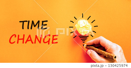 Time change symbol. Concept word Time change on beautiful orange paper. Businessman's hand. Light bulb icon. Beautiful orange paper background. Business time change concept. Copy space. 130425974