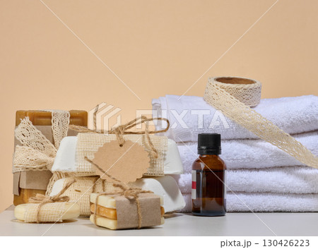 Spa and natural cosmetics items, white towels, several bars of handmade soap 130426223