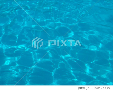 Blue water surface with sunlight reflections in a swimming pool. Leisure, recreation and summer lifestyle represented through clarity, refreshment and aquatic relaxation. 130426559
