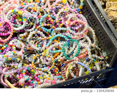 Colorful bead bracelets mixed in a box with multiple designs and textures. Jewelry, fashion and individuality expressed through accessory, consumer choice and cultural creativity. Colorful bead bracelets mixed in a box with multiple designs and textures. Jewelry, fashion and individuality expressed through accessory, consumer choice and cultural creativity. 130426698