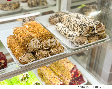 Bright candy turkish delight with nut filling arranged in a shop window. Confectionery, culture and culinary indulgence represented through gourmet sweets, tradition and consumer delight. 130426699