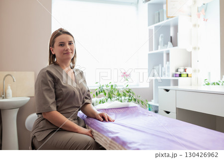 Portrait of a professional beautician in her cabinet ready to welcome next patient client and perform some spa procedures to them. Doctor cosmetologist waiting for a patient Portrait of a professional beautician in her cabinet ready to welcome next patient client and perform some spa procedures to them. Doctor cosmetologist waiting for a patient 130426962