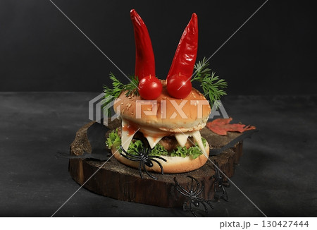 Halloween food concept. Scary hamburgers with fresh parsley leaves, tomatoes, cream cheese, onion and cutlet on old concrete background, low key, food delivery, cafe advertisement, Halloween food concept. Scary hamburgers with fresh parsley leaves, tomatoes, cream cheese, onion and cutlet on old concrete background, low key, food delivery, cafe advertisement, 130427444