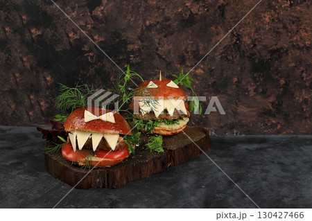 Halloween food concept.Two burgers with fresh parsley leaves, tomatoes, cream cheese, onions and cutlet on old concrete background, low key, food delivery, cafe advertisement, Halloween food concept.Two burgers with fresh parsley leaves, tomatoes, cream cheese, onions and cutlet on old concrete background, low key, food delivery, cafe advertisement, 130427466