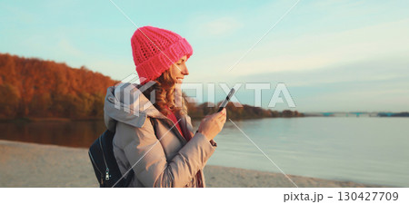 Travel, adventure, traveler woman with phone on the beach, girl holding smartphone on sea coast Travel, adventure, traveler woman with phone on the beach, girl holding smartphone on sea coast 130427709