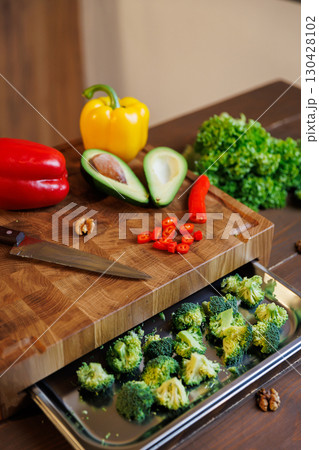 Fresh vegetables and avocado on cutting board ready for healthy meal preparation Fresh vegetables and avocado on cutting board ready for healthy meal preparation 130428102
