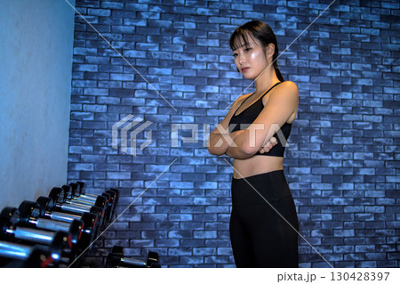 ダンベルの重量を選ぶ女性　ジムで運動するかっこいい女性　筋トレ女子　 130428397