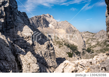 Scenic View Of Zugspitze And Jubilee Ridge From Via Ferrata Alpspitze: Rugged Rocky Peaks Of The Bavarian Alps Under Clear Blue Sky 130428398