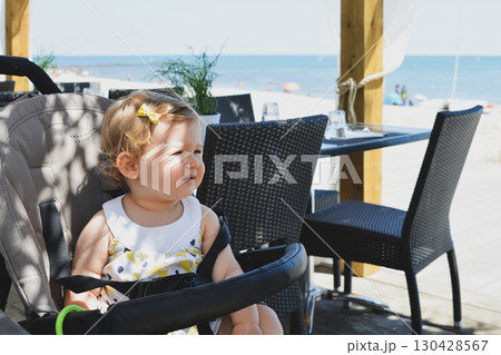 Girl child in a stroller in a restaurant on vacation 130428567